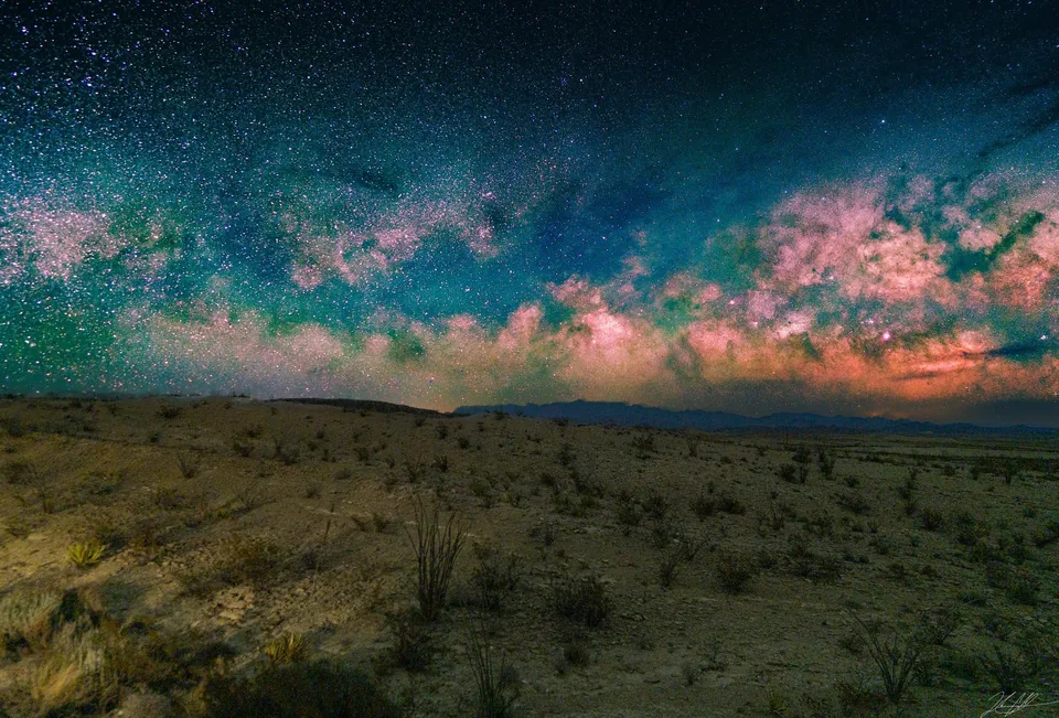 Colorful Milky Way over open grassland