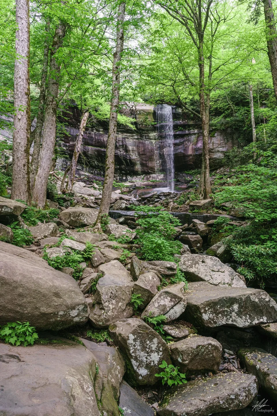 Waterfall over a boulder-strewn forest slope