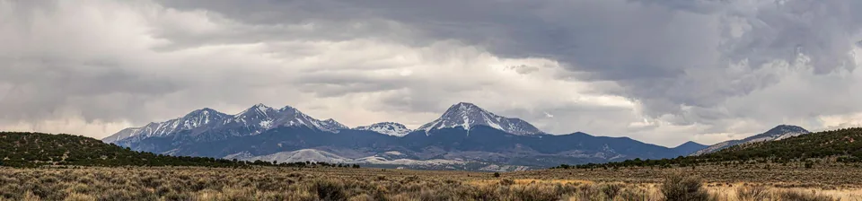 Panorama of snow-capped peaks across open plains