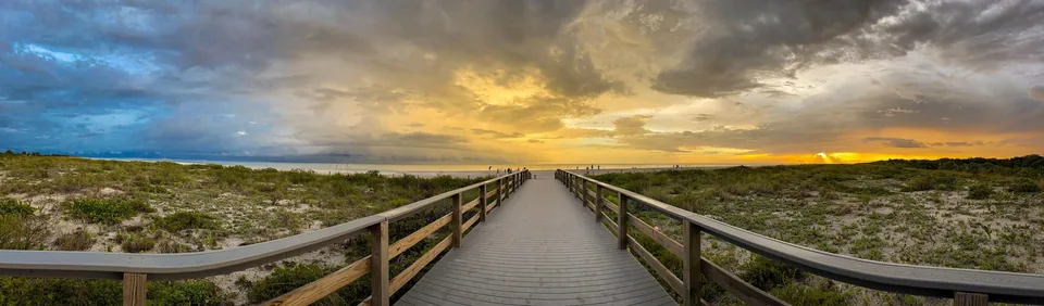 Boardwalk leading toward a golden sunset