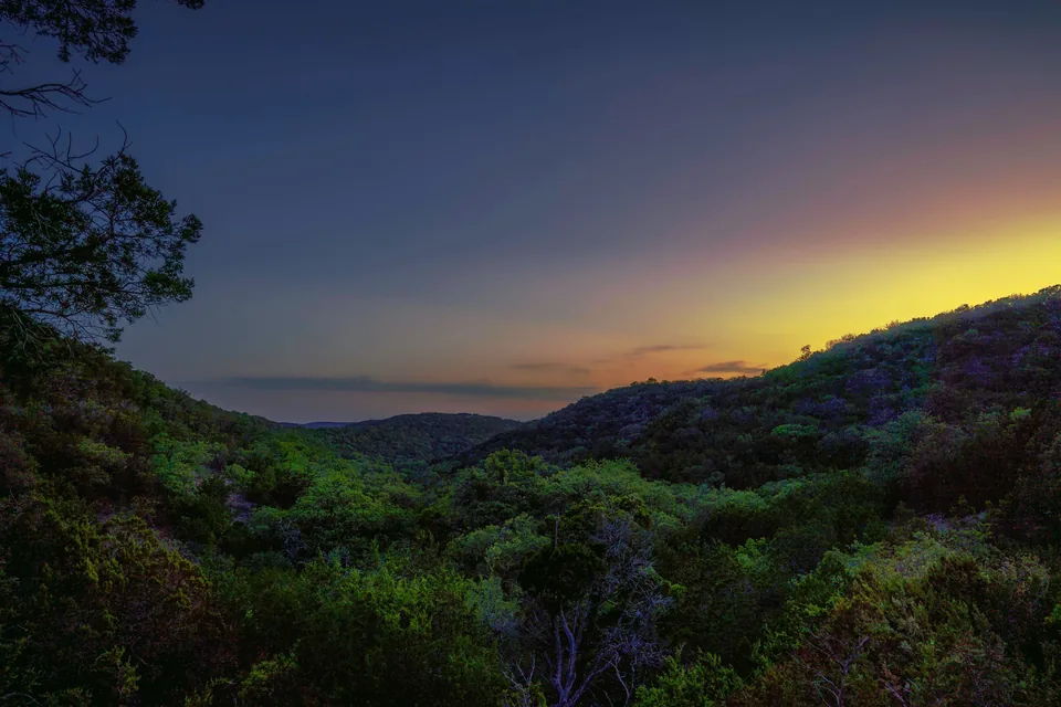 Sunset glowing over forested hills