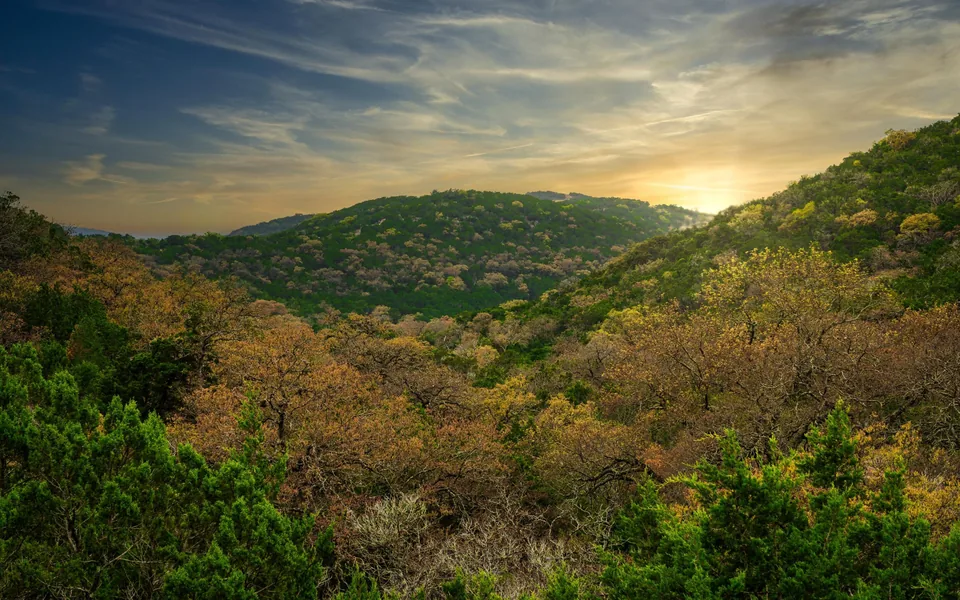 Sun setting over a green valley