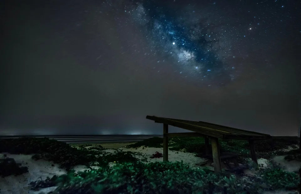 Milky Way above a shelter on a coastal shore