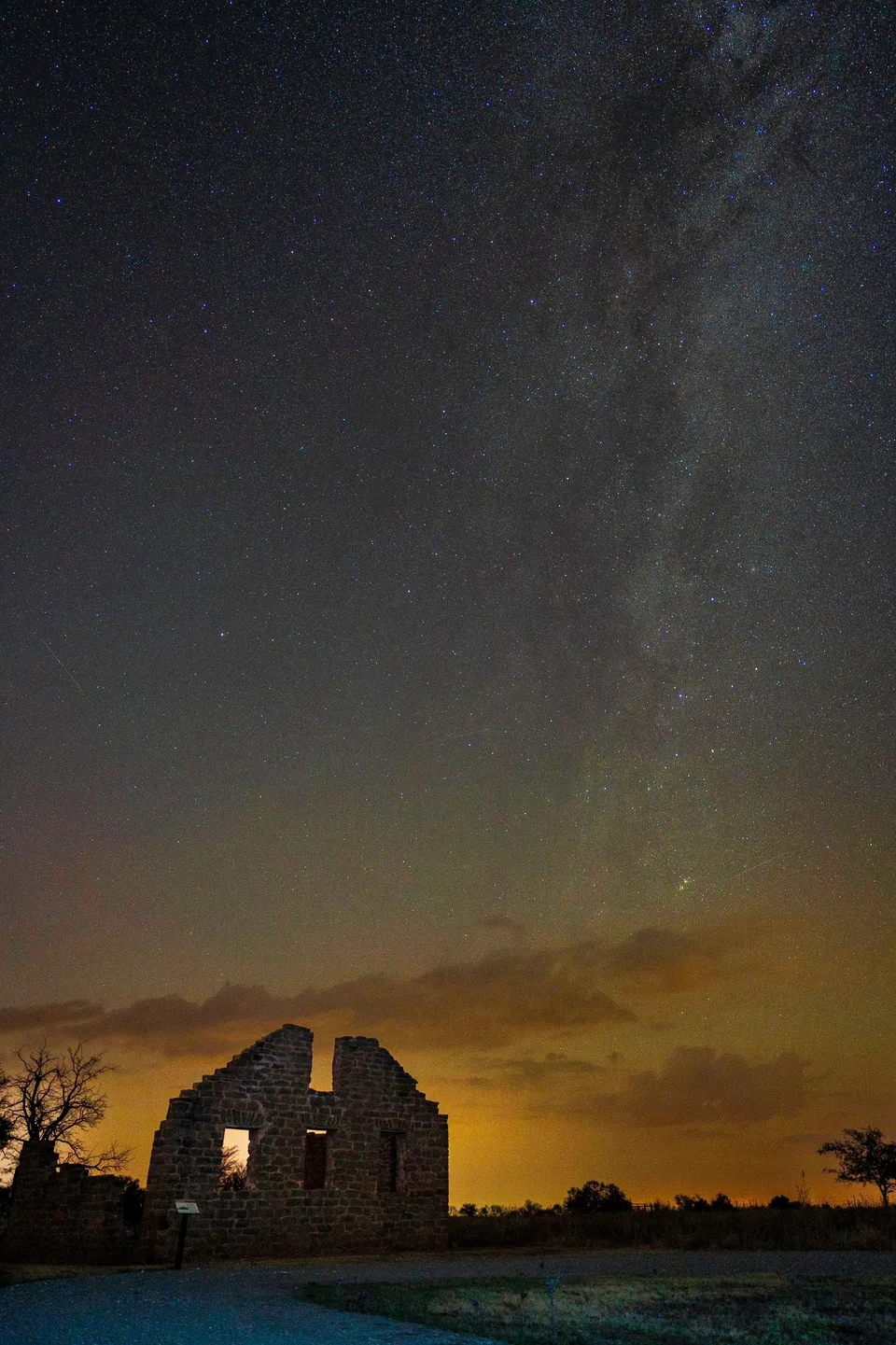Stone ruin beneath stars and a glowing horizon
