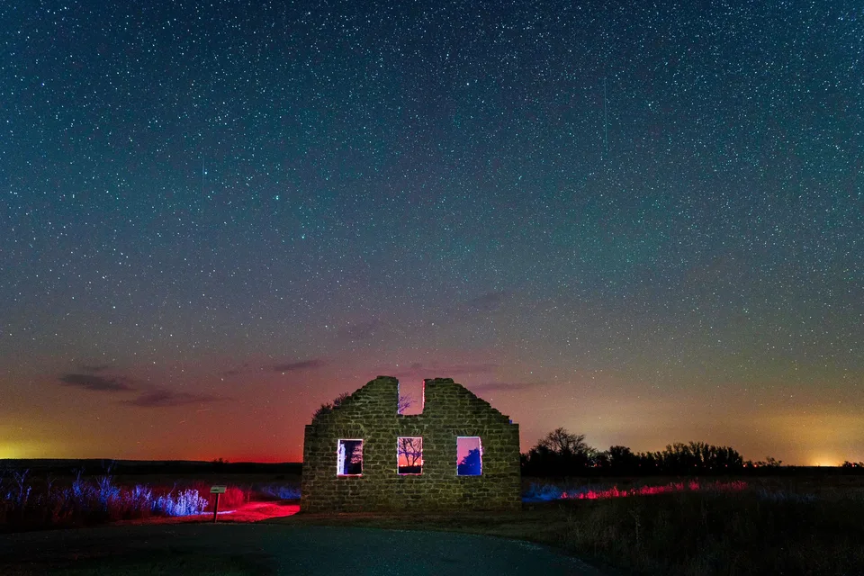 Stone ruin lit red under a starry sky