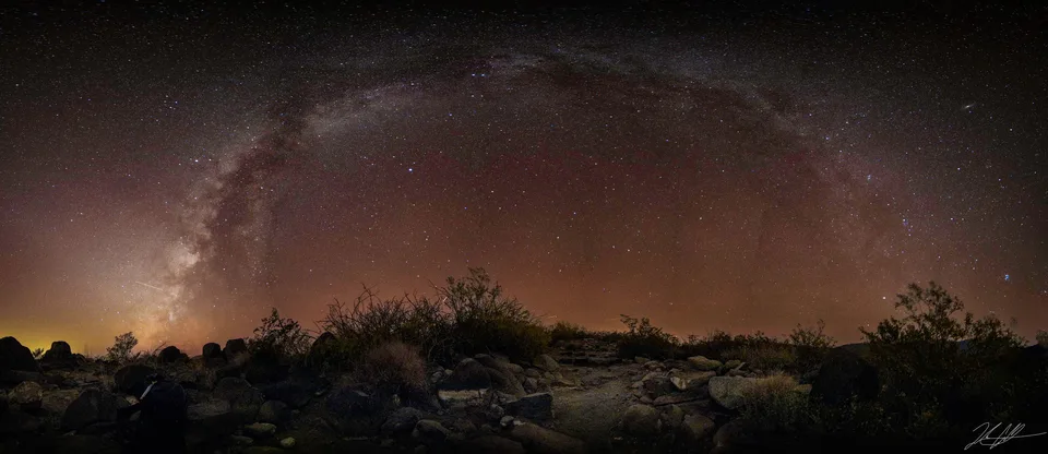 Panorama of the Milky Way arching over the desert